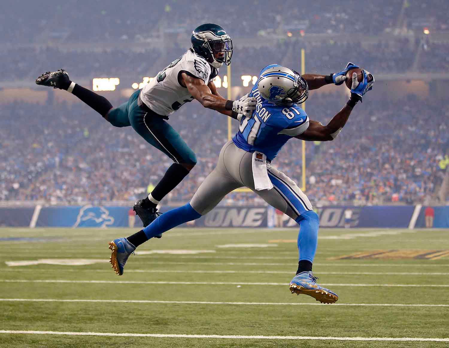 Photo of a receiver being tackled while catching the ball