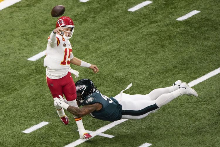 Photo of a quarterback being tackled after throing the ball